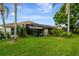 Lush, green backyard features a pool with a screened enclosure, providing a private oasis at 1154 Seneca Trl, St Cloud, FL 34772