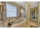 Relaxing bathroom featuring a large soaking tub next to a window that provides natural light at 1154 Seneca Trl, St Cloud, FL 34772