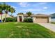 Charming single-story home featuring a well-manicured lawn, attached garage and vibrant tropical landscaping at 1154 Seneca Trl, St Cloud, FL 34772