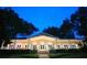 Stately community building with well-lit facade, manicured lawn, and mature trees at dusk at 116 Crown Oaks Way # 116, Longwood, FL 32779