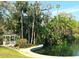 Picturesque gazebo nestled beside a serene lake with lush tropical foliage and towering palm trees at 116 Crown Oaks Way # 116, Longwood, FL 32779