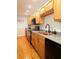 Well-lit kitchen featuring wooden cabinets, a copper sink, and modern appliances at 116 Crown Oaks Way # 116, Longwood, FL 32779