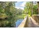 Scenic view of a tranquil pond from a wooden bridge, surrounded by lush greenery and mature trees at 116 Crown Oaks Way # 116, Longwood, FL 32779