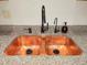 Close up of a hammered copper double sink with a modern black faucet and granite counter top at 116 Crown Oaks Way # 116, Longwood, FL 32779