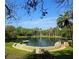 Scenic view of a natural spring surrounded by lush greenery and palm trees under a blue sky at 116 Crown Oaks Way # 116, Longwood, FL 32779