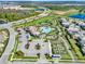 Aerial view of community pool, tennis courts, gardens, and amenities near highway and neighborhood at 12024 Sonnet Ave, Orlando, FL 32832