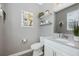 Stylish powder room with gray walls, floating shelves, and updated fixtures offering a modern touch at 12024 Sonnet Ave, Orlando, FL 32832