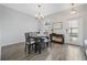 Dining room features a dark wood table, chandelier, and bright natural light from the window at 12024 Sonnet Ave, Orlando, FL 32832