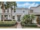 Charming two-story townhome featuring decorative shingles, lush landscaping, and a welcoming front entrance at 12024 Sonnet Ave, Orlando, FL 32832