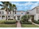 Charming two-story home with landscaped yard, lush palms, and welcoming front entryway at 12024 Sonnet Ave, Orlando, FL 32832