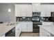 Modern kitchen featuring white cabinets, stainless steel appliances, subway tile backsplash, and stone countertops at 12024 Sonnet Ave, Orlando, FL 32832