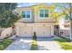 Charming two-story townhome with tan stucco, matching garage doors, and tile roof at 1244 Romani Ave # 1244, Davenport, FL 33896