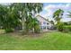 Large backyard with an iron fence, mature trees, and lush grass providing a serene outdoor setting at 12820 Butler Bay Ct, Windermere, FL 34786