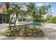 Backyard featuring a swimming pool with a rock waterfall feature set in a brick-paved patio and tropical foliage at 12820 Butler Bay Ct, Windermere, FL 34786