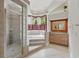 Bathroom featuring a large soaking tub, glass shower, and vanity with wooden cabinets at 12820 Butler Bay Ct, Windermere, FL 34786