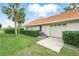 Exterior view of home with a red tile roof, an attached garage, and manicured landscaping in a green lawn at 12820 Butler Bay Ct, Windermere, FL 34786