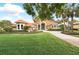 Beautiful single-story home with an orange roof, lush green lawn, and tall palm trees at 12820 Butler Bay Ct, Windermere, FL 34786