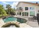 Inviting pool and spa with stone accents, lounge chairs, and a lovely view of the home's balcony at 12820 Butler Bay Ct, Windermere, FL 34786