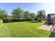 Expansive backyard featuring lush lawn, mature trees, playground set and outdoor seating area at 12860 Jacob Grace Ct, Windermere, FL 34786