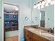 Bright bathroom with wood vanity, double sinks, and a view into a bedroom at 12860 Jacob Grace Ct, Windermere, FL 34786