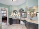 Luxurious bathroom with dual vanities, granite countertops, decorative mirrors, and elegant lighting at 12860 Jacob Grace Ct, Windermere, FL 34786