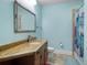 Bright bathroom with a single vanity, framed mirror, and tiled shower/tub combo at 12860 Jacob Grace Ct, Windermere, FL 34786