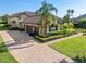 Aerial shot of the house showcasing the three-car garage, lush landscaping, and brick-paved driveway at 12860 Jacob Grace Ct, Windermere, FL 34786