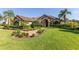 Charming home featuring a tile roof, arched entryway, manicured lawn and lush landscaping at 12860 Jacob Grace Ct, Windermere, FL 34786