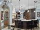 Spacious kitchen featuring dark wood cabinetry, granite countertops, dual islands, and pendant lighting at 12860 Jacob Grace Ct, Windermere, FL 34786