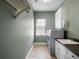 Laundry room with washer, dryer, sink, cabinets, and storage rack at 12860 Jacob Grace Ct, Windermere, FL 34786