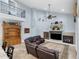 Bright living room featuring a fireplace, high ceilings, upper balcony, and a luxurious leather sectional at 12860 Jacob Grace Ct, Windermere, FL 34786