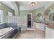Elegant bathroom with tub, glass block wall, double vanities, and decorative lighting at 12860 Jacob Grace Ct, Windermere, FL 34786