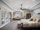 Large main bedroom with sitting area, ceiling fan, and French doors to the outside at 12860 Jacob Grace Ct, Windermere, FL 34786