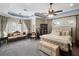 Bright main bedroom featuring tray ceilings, a sitting area, plush carpeting and French doors to the patio at 12860 Jacob Grace Ct, Windermere, FL 34786