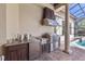 A stainless steel grill and granite countertops highlight this outdoor kitchen under a covered patio at 12860 Jacob Grace Ct, Windermere, FL 34786