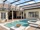 This covered pool with a spa features elegant pillars, an outdoor kitchen, and an attached lanai at 12860 Jacob Grace Ct, Windermere, FL 34786