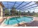 A beautiful pool and spa area, surrounded by lush landscaping, sits inside a screened enclosure at 12860 Jacob Grace Ct, Windermere, FL 34786