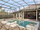 Beautifully designed screened in pool with jacuzzi and access to outdoor kitchen and dining area at 12860 Jacob Grace Ct, Windermere, FL 34786