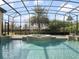 This screened-in pool features a spa, fountains, and tiled accents, surrounded by well-maintained landscaping at 12860 Jacob Grace Ct, Windermere, FL 34786