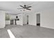 Open living room with grey floors adjoining the kitchen boasts natural light and neutral finishes at 13128 Devonshire Rd, Orlando, FL 32832