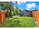 Wide shot of the backyard featuring a screened-in pool, lush green grass, and a privacy fence at 137 Spring Chase Cir, Altamonte Springs, FL 32714