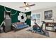 A stylish bedroom showcasing a soccer theme, featuring a futon, an arcade game and a ceiling fan at 137 Spring Chase Cir, Altamonte Springs, FL 32714