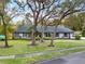 Inviting single-story home featuring mature trees, lush green lawn, and manicured landscaping at 137 Spring Chase Cir, Altamonte Springs, FL 32714