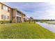 Exterior view of home on lush lawn and water, with screened porches at 145 N Pearl Lake Cswy # 104, Altamonte Springs, FL 32714