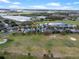 Aerial view of the house from the golf course with a pond and clear blue skies at 15144 Spinnaker Cove Ln, Winter Garden, FL 34787