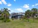 A beautiful backyard features a screened-in pool and lush landscaping with various palm trees and a manicured lawn at 15144 Spinnaker Cove Ln, Winter Garden, FL 34787