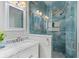 Bathroom featuring a white vanity, large mirror, and a glass-enclosed shower with blue tile at 15144 Spinnaker Cove Ln, Winter Garden, FL 34787