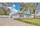 Rear view of a bright white single story home with a long driveway and ample parking at 1536 Errol Pkwy, Apopka, FL 32712