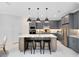 Stylish kitchen featuring gray cabinets, a center island with seating, and modern pendant lighting at 15919 Winding Bluff Dr, Montverde, FL 34756