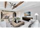 Cozy living room with ceiling beams, a large TV, and open flow into the dining area at 15919 Winding Bluff Dr, Montverde, FL 34756